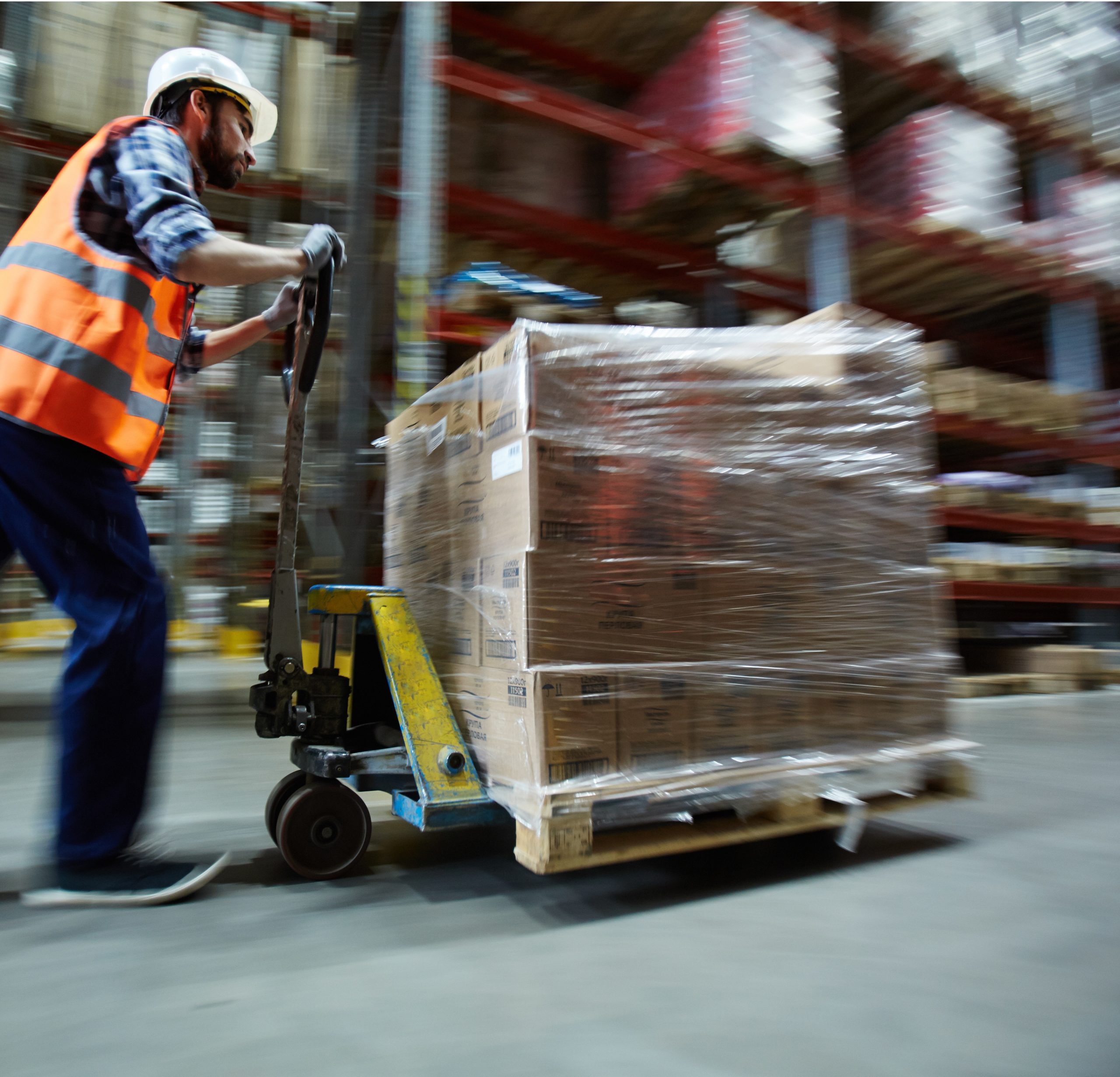 Man in uniform pushing cargo on forklift