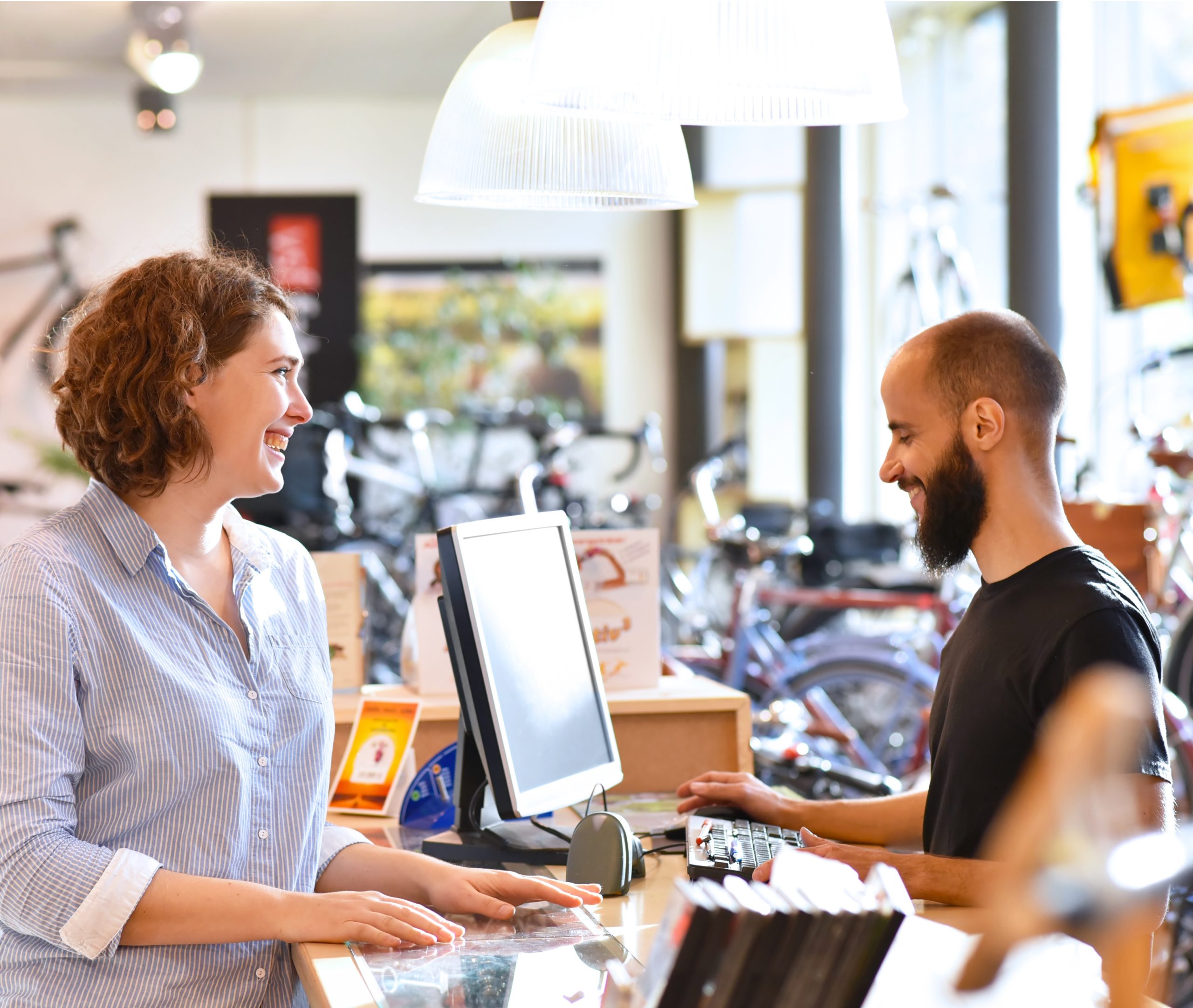 Lifestyle Shopping - junge Frau kauft in einem Fahrradladen ein, Beratung durch Verkäufer